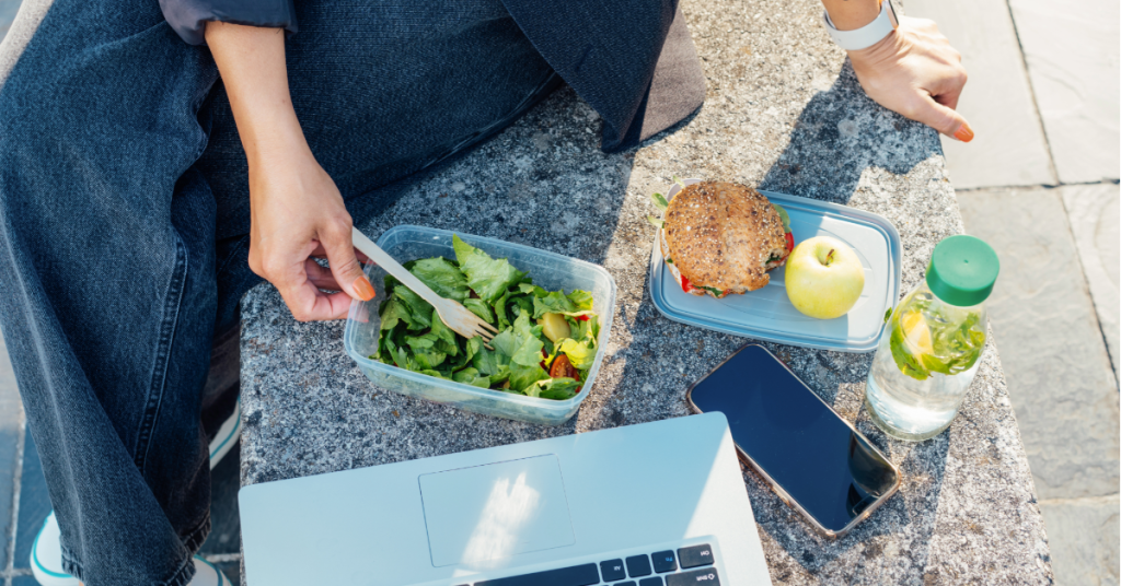 Woman having her lunch break in the sun eating healthy food